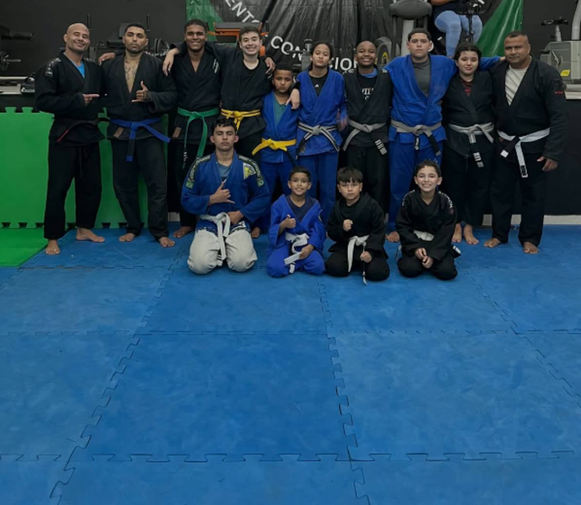 Turma de Jiu-Jitsu do Studio WFit reunida no tatame, adultos e crianças
